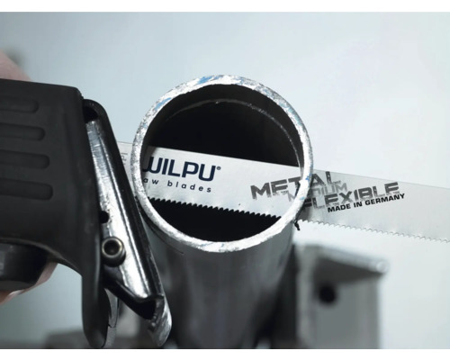 Pílový list na kov pri rezaní kovovej rúrky.