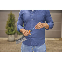 Osoba pripája kefu k záhradnej hadici