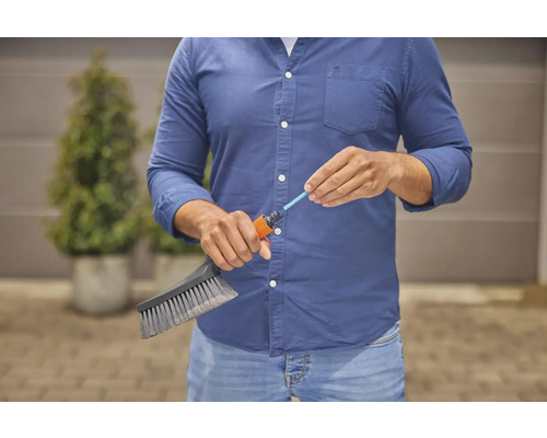 Osoba pripája kefu k záhradnej hadici