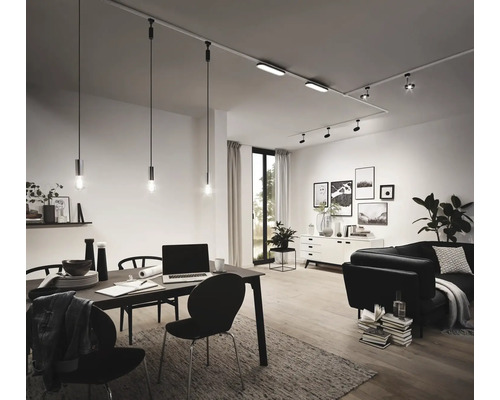 Obývacia izba s jedálenským stolom, pohovkou a koľajnicovým systémom s reflektormi a závesnými svietidlami.