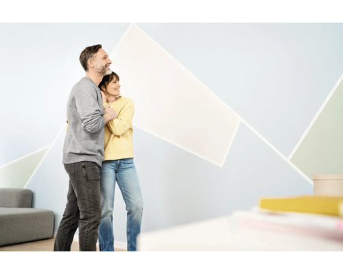 Pár si prezerá geometrický dizajn stien v obývacej izbe.