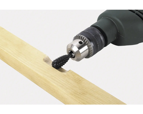 Vŕtačka s rašpľovým nadstavcom obrába kus dreva.