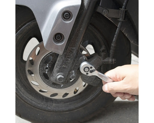 Osoba používa račňu na motocykli.