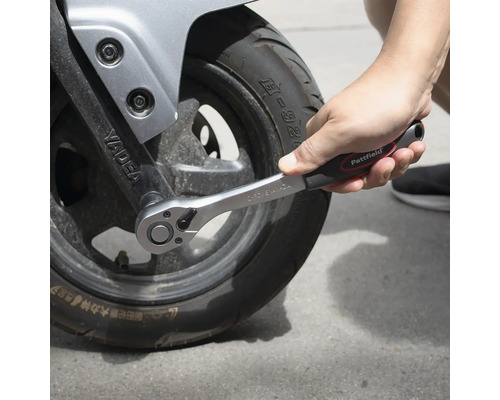 Uťahovanie motocyklovej pneumatiky račňou.