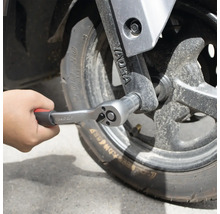 Ruka upevňuje račňu na koleso.