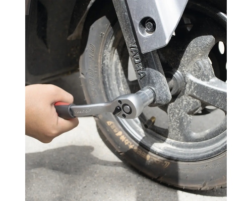 Ruka upevňuje račňu na koleso.