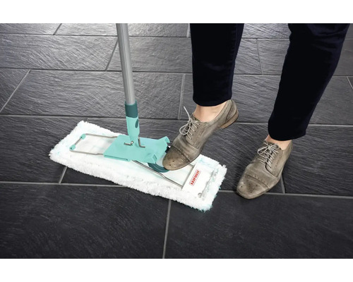Mop v akcii na tmavej dlažbe, ovládaný osobou v topánkach.