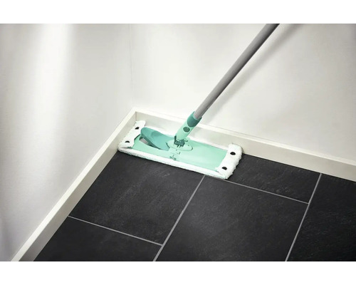 Mop na tmavej dlažbe pri bielej stene