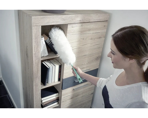 Žena čistí policu prachovkou