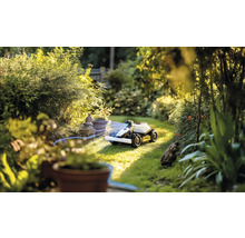 Robotická kosačka v prevádzke v zelenej záhrade