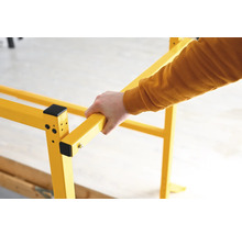 Žlté lešenie s rukou, ktorá ho drží