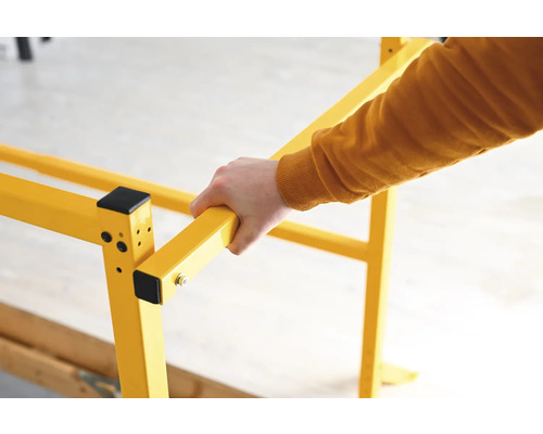 Žlté lešenie s rukou, ktorá ho drží