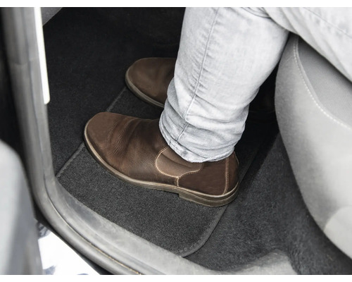 Priestor pre nohy v aute s podlahovou rohožou a koženou topánkou