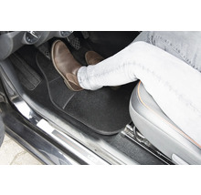 Interiér vozidla s podlahovou rohožou a nohou na pedáli