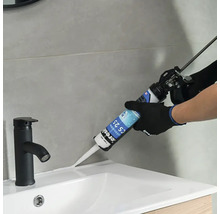 Aplikácia tesniaceho materiálu na okraj umývadla pomocou kartuše.