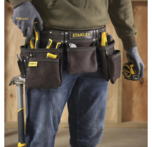 Remeselník s opaskom na náradie značky Stanley, vybavený rôznym náradím