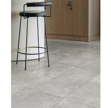 Interiér so sivou dlažbou a barovou stoličkou