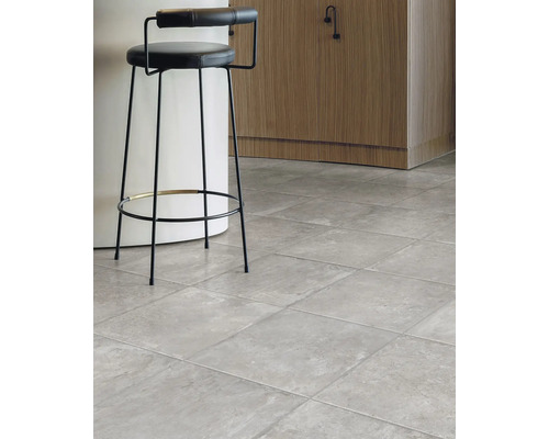 Interiér so sivou dlažbou a barovou stoličkou