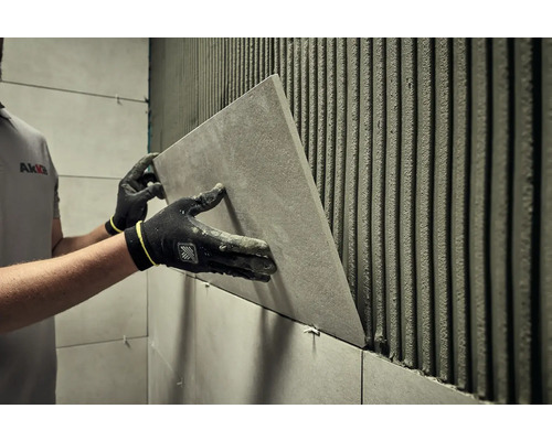 Dlaždič inštaluje obklad v kúpeľni