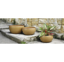 Tri okrúhle kvetináče na kamenných schodoch, jeden z nich s rastlinou