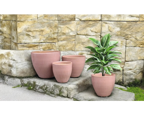 Kvetináče rôznych veľkostí pred kamenným múrom