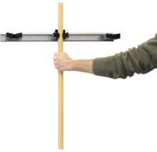 Muž upevňuje rukoväť do nástenného držiaka na náradie