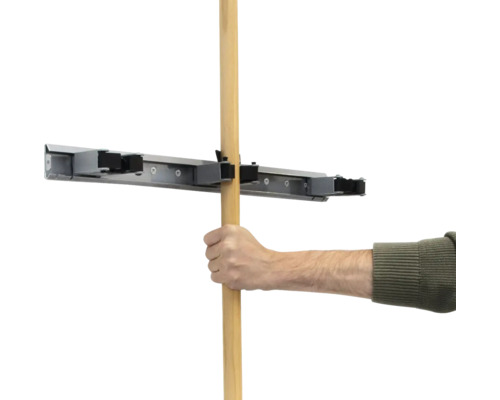 Ruka vkladá drevenú násadu do držiaka na náradie.