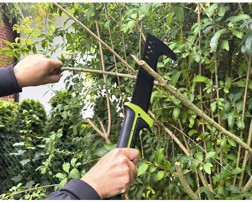 Osoba reže konáre na strome pomocou prerezávacej píly