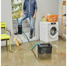 Zaplavená pivnica s mužom v gumových topánkach, pumpou a práčkou