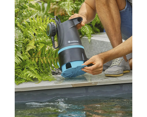 Ponorné kalové čerpadlo Gardena je pridržiavané v rybníku.