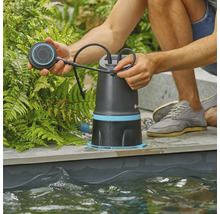 Muž obsluhuje jazierkové čerpadlo na okraji jazierka.