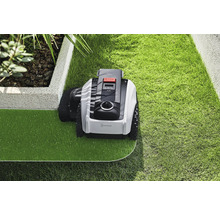 Robotická kosačka na trávu pri starostlivosti o trávnik v záhrade.