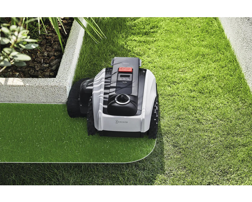 Robotická kosačka na trávu pri starostlivosti o trávnik v záhrade.