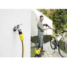 Muž čistí bicykel pomocou vysokotlakového čističa Kärcher. Vidieť je aj vodovodný kohútik s hadicovou prípojkou.