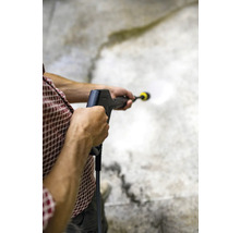 Osoba používa vysokotlakový čistič na čistenie povrchu.