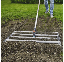 Úprava pôdy pomocou urovnávacej lišty v záhrade.