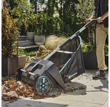 Záhradná scéna so zberačom lístia v prevádzke, ktorý zbiera lístie.