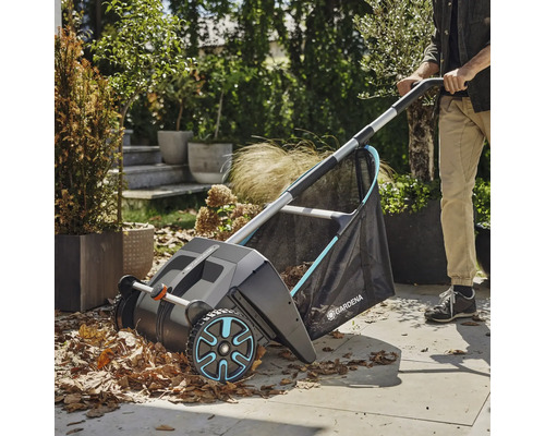 Záhradná scéna so zberačom lístia v prevádzke, ktorý zbiera lístie.