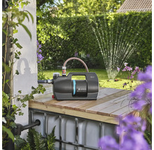 Záhradné čerpadlo Gardena na drevenej konštrukcii so záhradou v pozadí.