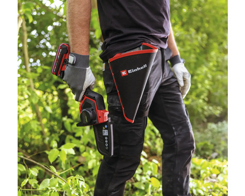 Osoba s akumulátorovou prerezávacou pílou Einhell a puzdrom s logom Einhell
