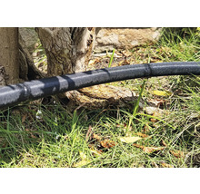 Zavlažovacia hadica v záhrade s unikajúcou vodou