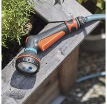 Záhradná hadicová sprcha na drevenom povrchu