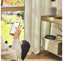 Osoba ovláda aplikáciu na zavlažovanie záhrady na smartfóne