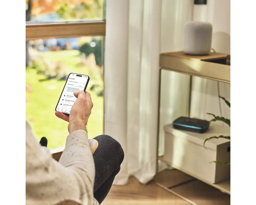 Osoba ovláda aplikáciu na zavlažovanie záhrady na smartfóne