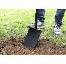 Osoba bodá rýľom do zeme.