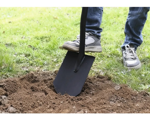 Osoba bodá rýľom do zeme.