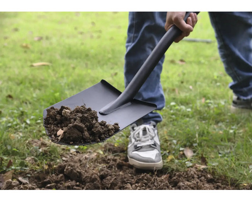 Osoba lopatou naberá hlinu.