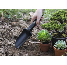 Záhradná lopatka s označením používaná vedľa rastlín v kvetináčoch.