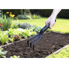 Záhradný kultivátor používaný v zeleninovom záhone.