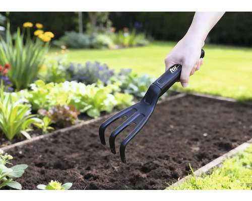 Záhradný kultivátor používaný v zeleninovom záhone.